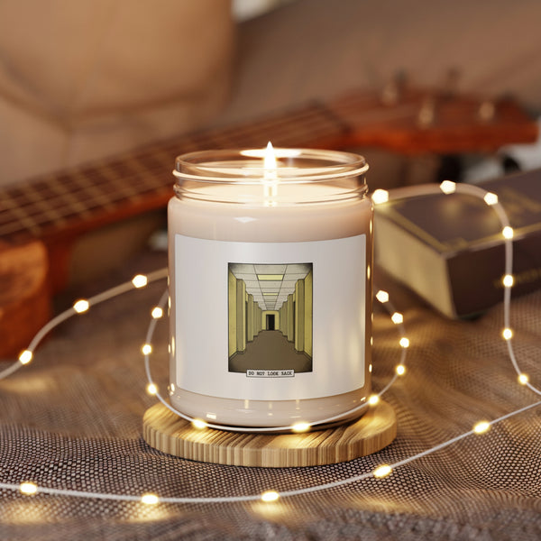 Candle with a dog illustration on a wooden coaster surrounded by string lights and a guitar in the background
