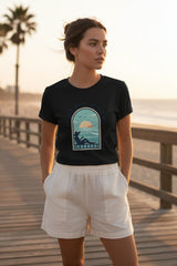Black t-shirt with a graphic design of a person by the sea on a white background
